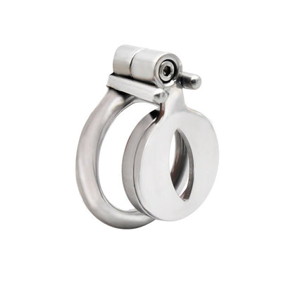 A flat, circular stainless steel chastity device with a front screw lock mechanism and a key inserted in it.