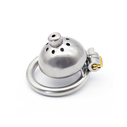 The image shows an ultra-small stainless steel chastity device with a dome-shaped top and a urethral tube attached. The device is designed for male use and features a metallic finish with a small ring for the penis and a key lock for secure storage.