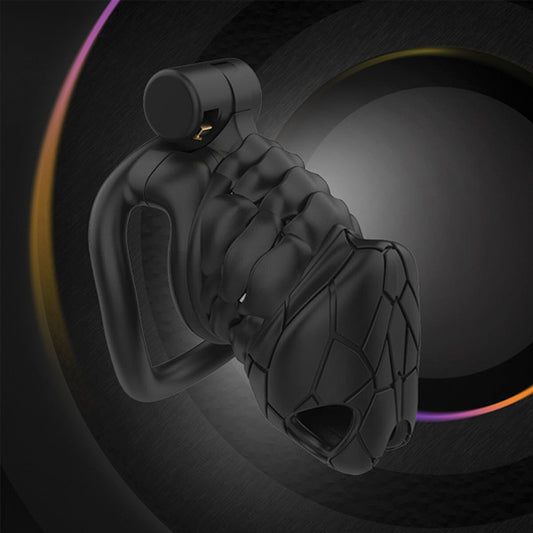 A black chastity cage with a cobra-inspired texture and a small circular front, set against a dark background with a colorful light trail.